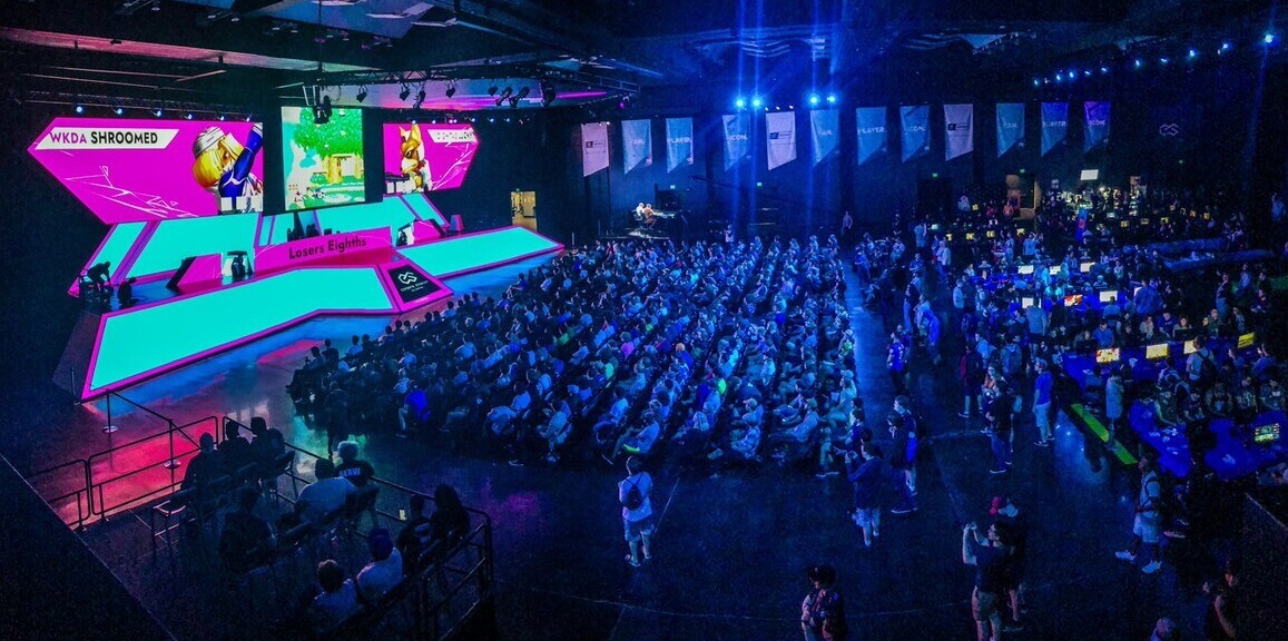 Een levendige esports-stadion gevuld met toeschouwers en neonverlichting, met een futuristisch podium en grote schermen voor een gaming-toernooi.